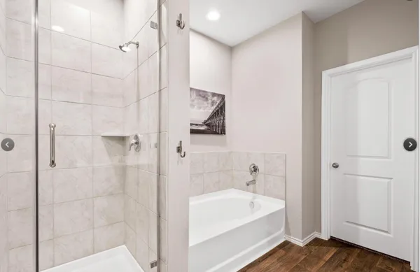a bathroom with a white bath tub a shower and a sink
