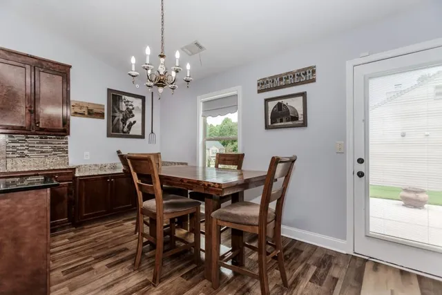 a view of a dining room with furniture a chandelier and wooden floor