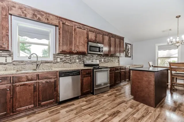 a kitchen with stainless steel appliances granite countertop a sink stove and microwave