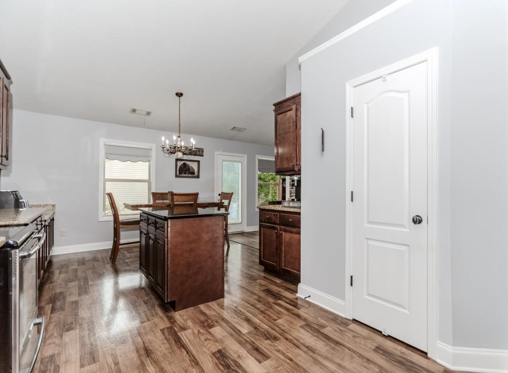 1411 Silvergate Way Winder, GA 30680 - Photo 17 of 38 a dining room with kitchen island stainless steel appliances sink and wooden floor
