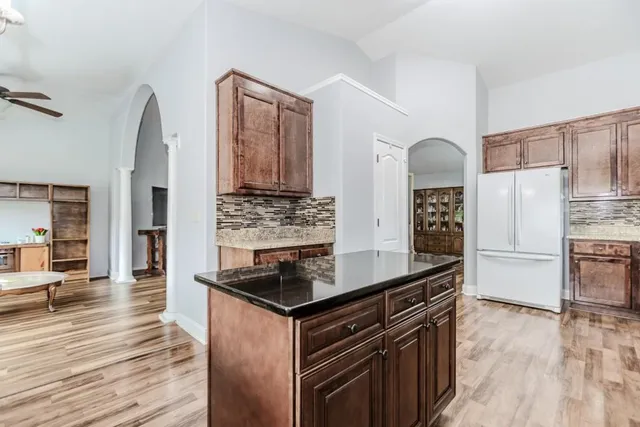a kitchen with granite countertop a stove cabinets and wooden floor