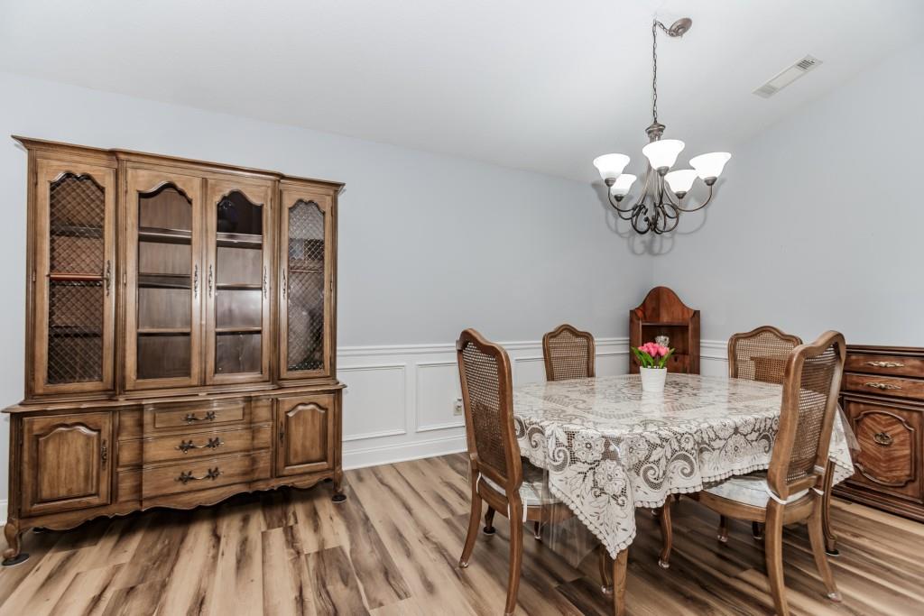 1411 Silvergate Way Winder, GA 30680 - Photo 19 of 38 a dining room with furniture a chandelier and wooden floor
