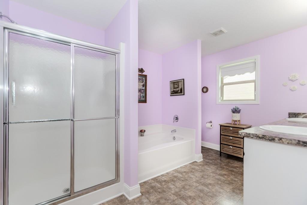 1411 Silvergate Way Winder, GA 30680 - Photo 23 of 38 a bathroom with a granite countertop sink a toilet a shower and a bathtub