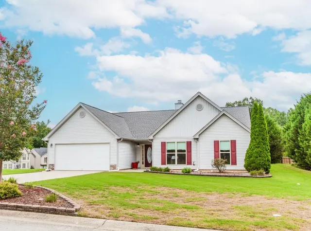 a view of a house with a big yard and large trees