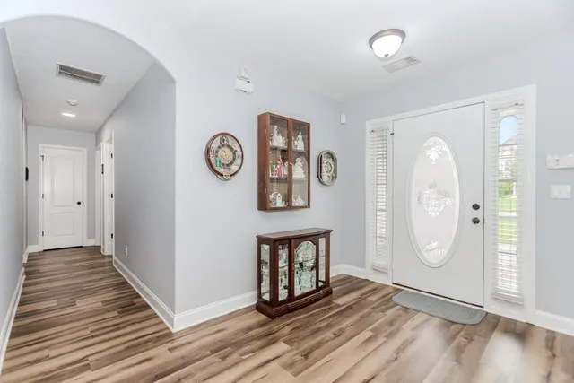a view of an empty room with wooden floor and a large window