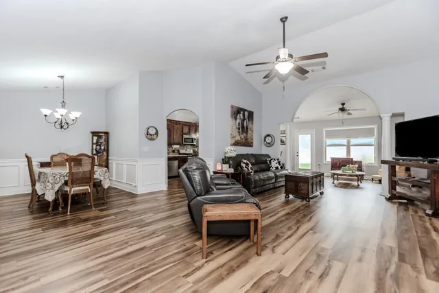a living room with furniture a flat screen tv and a window