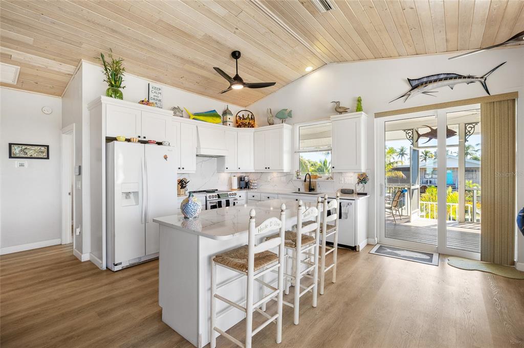 9712 Little Gasparilla Placida, FL 33946 - Photo 17 of 58 a kitchen with stainless steel appliances a dining table chairs refrigerator and sink