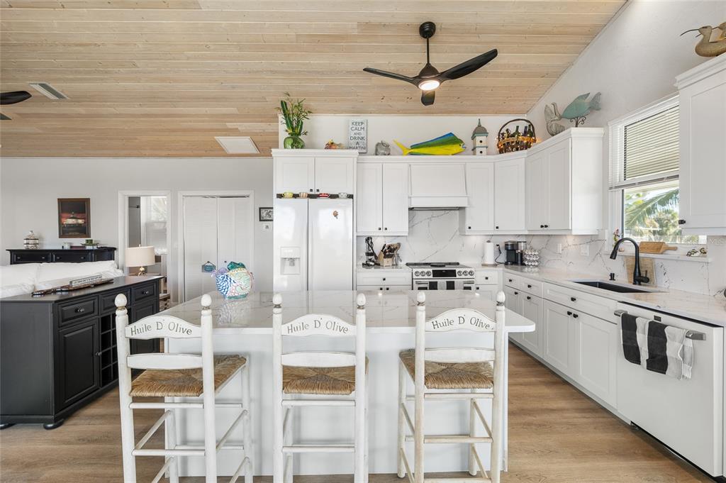 9712 Little Gasparilla Placida, FL 33946 - Photo 20 of 58 a kitchen with stainless steel appliances granite countertop a stove a sink dishwasher and white cabinets with wooden floor