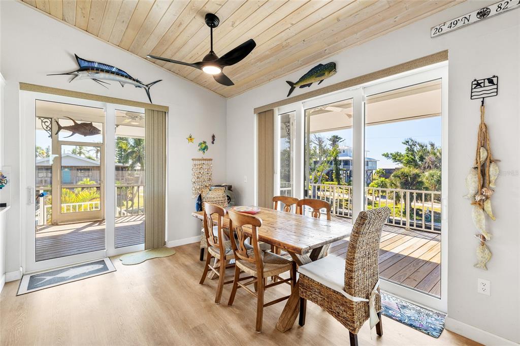 9712 Little Gasparilla Placida, FL 33946 - Photo 23 of 58 a view of a dining room with furniture large windows and wooden floor