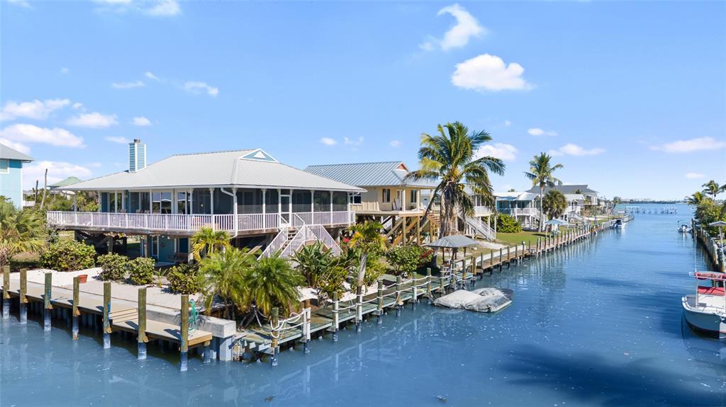 9712 Little Gasparilla Placida, FL 33946 - Photo 5 of 58 a front view of a house with swimming pool patio and outdoor seating