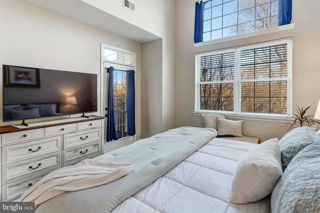 a bedroom with a large bed and a flat screen tv