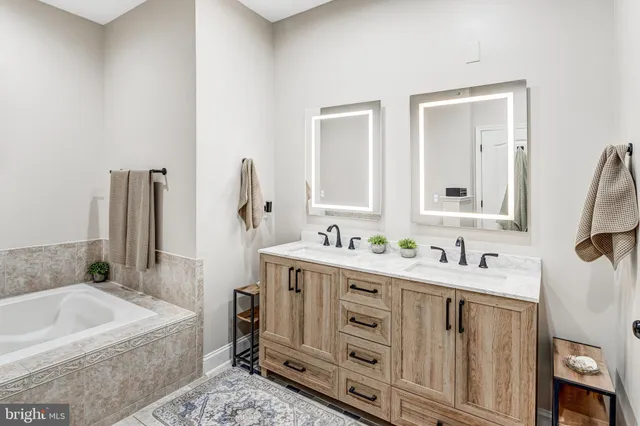 a bathroom with a tub sink and mirror