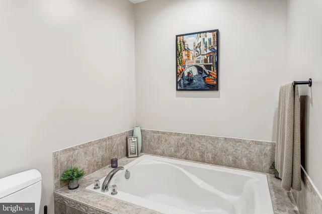 a bath tub sitting next to a white toilet and vanity