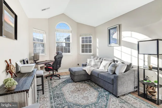 a living room with furniture fireplace and a large window
