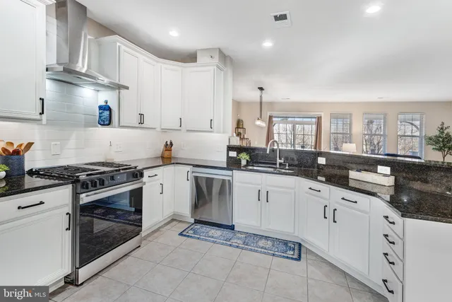 a kitchen with granite countertop white cabinets and appliances