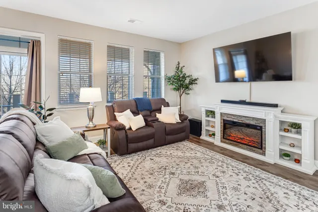 a living room with furniture a flat screen tv and a fireplace