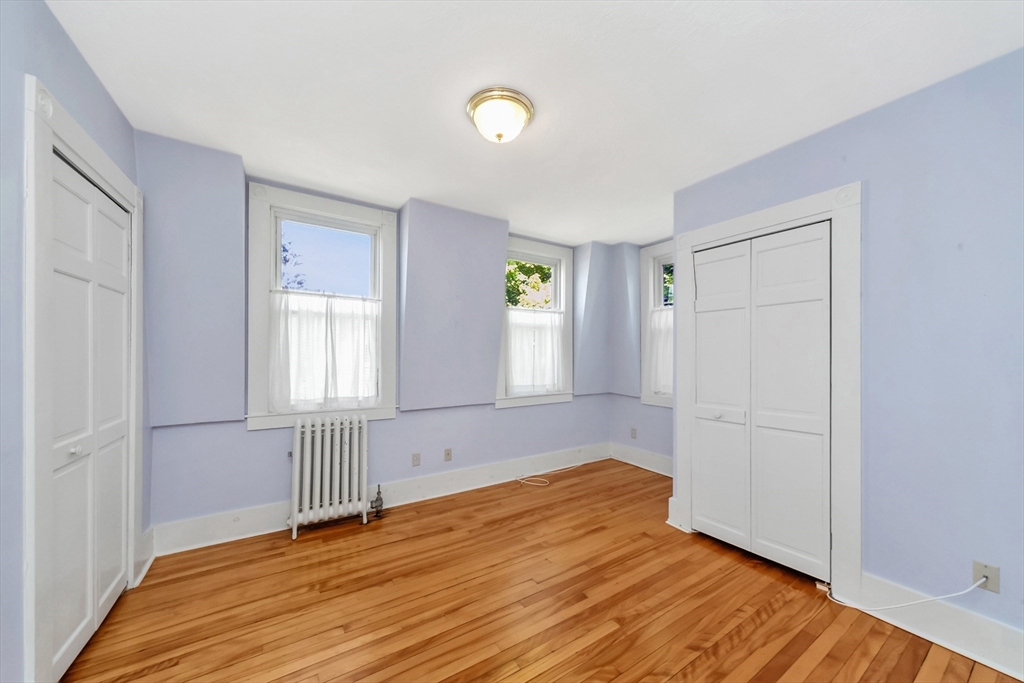 89 1/2 Walnut Street Clinton, MA 01510 - Photo 22 of 36 an empty room with wooden floor and windows