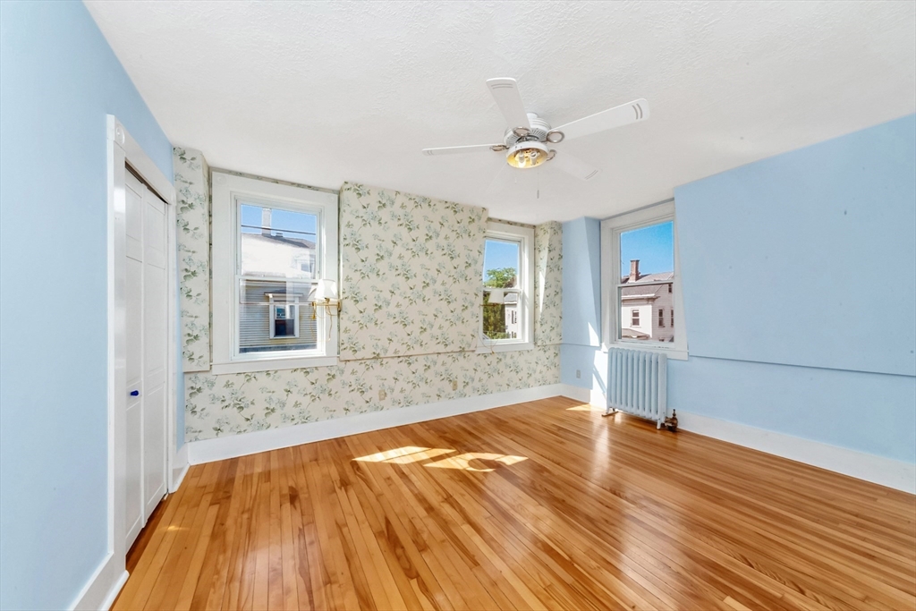 89 1/2 Walnut Street Clinton, MA 01510 - Photo 26 of 36 a view of empty room with wooden floor and fan