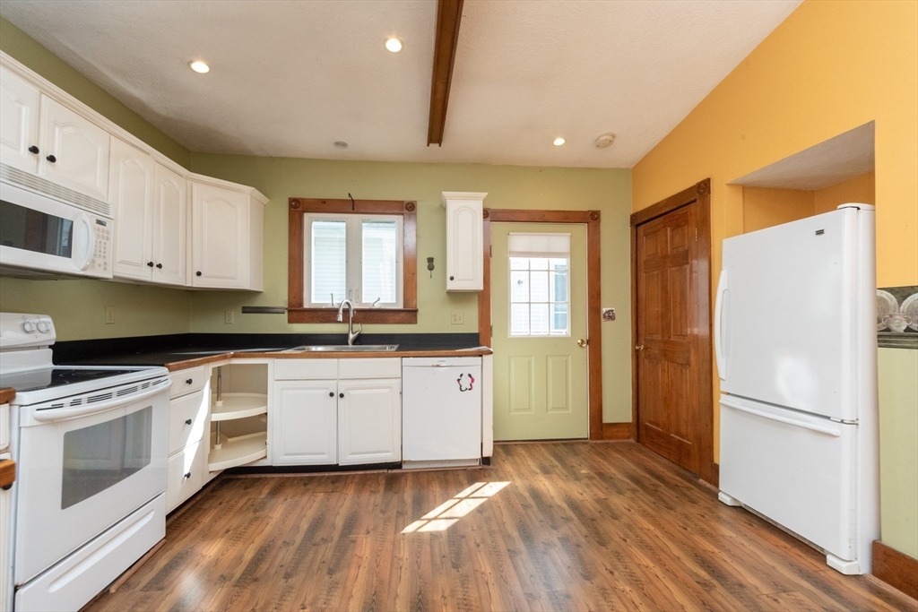 89 1/2 Walnut Street Clinton, MA 01510 - Photo 9 of 36 a kitchen with a refrigerator a sink and dishwasher with wooden floors
