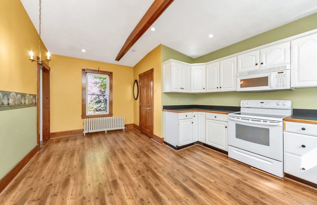89 1/2 Walnut Street Clinton, MA 01510 - Photo 10 of 36 a kitchen with granite countertop a stove a sink and white cabinets with wooden floor