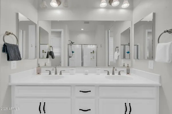 a en suite bathroom with a double vanity sink and a mirror