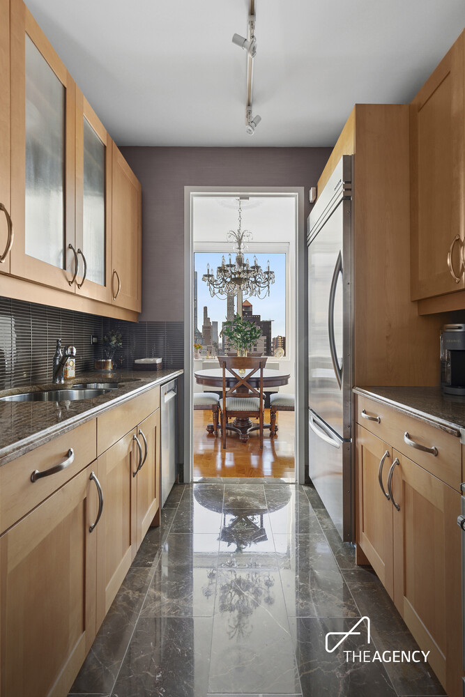 401 East 60th Street, Unit 35B Manhattan, NY 10022 - Photo 4 of 13 a kitchen with stainless steel appliances granite countertop a refrigerator a stove and white cabinets with wooden floor