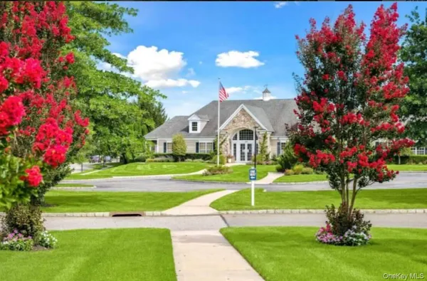 a view of a white house with a big yard and fountain