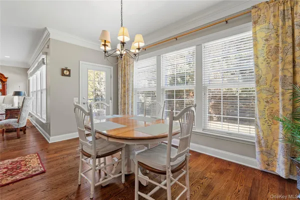 a dining room with furniture a chandelier and wooden floor