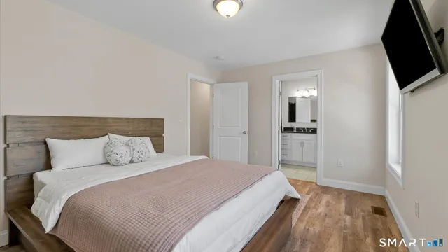 a bathroom with a granite countertop sink vanity mirror and toilet