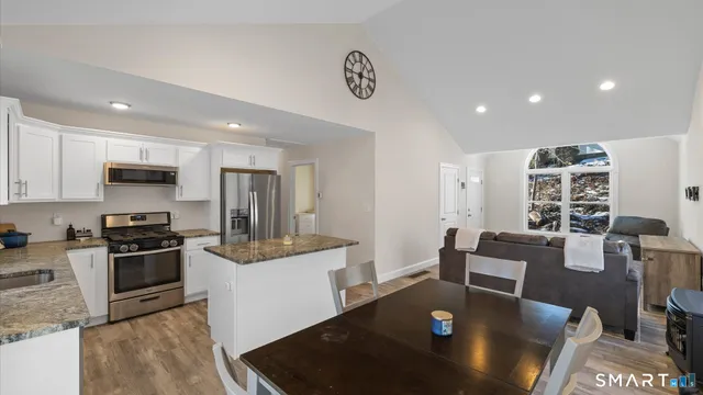 a kitchen with stainless steel appliances granite countertop a refrigerator a sink a stove a microwave and island