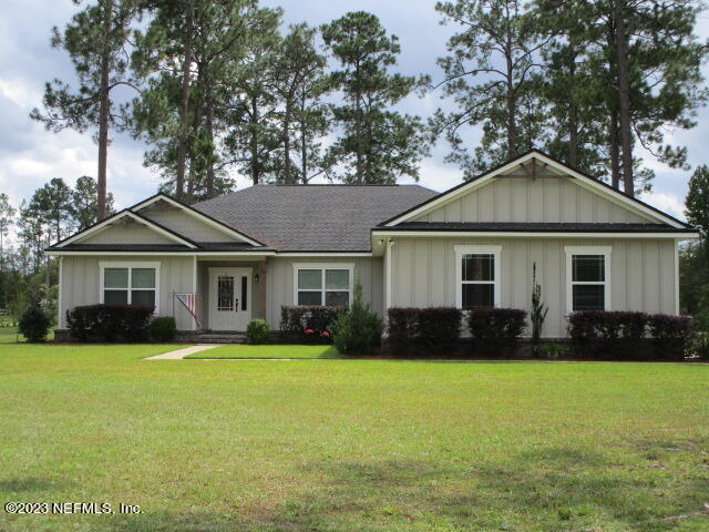 a front view of a house with a garden and trees