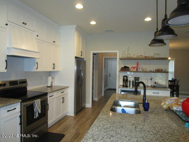 3704 Pete Johnson Road Macclenny, FL 32063 - Photo 7 of 18 a kitchen with stainless steel appliances granite countertop a sink a stove and a refrigerator