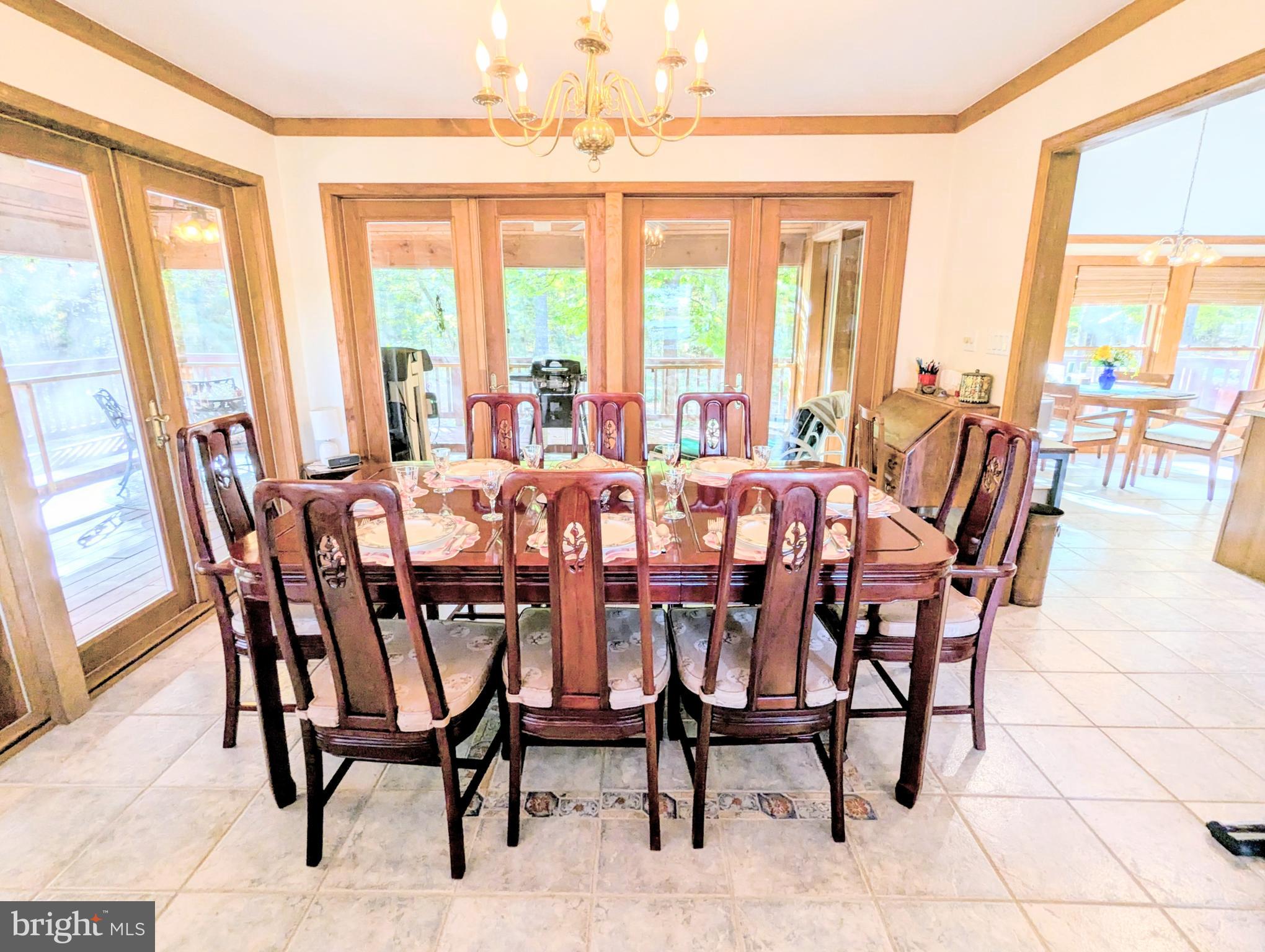 2006 Bennett Point Road Queenstown, MD 21658 - Photo 17 of 58 a dining room with furniture a chandelier and wooden floor