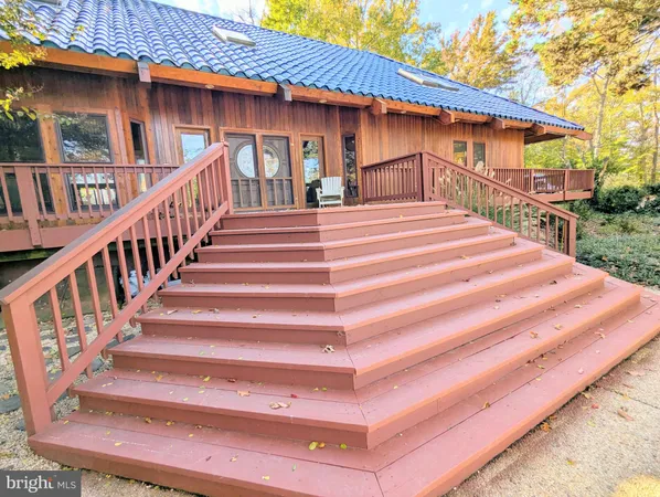 a view of backyard with deck and seating space