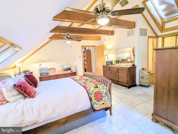 a bedroom with a bed and a dresser with rug