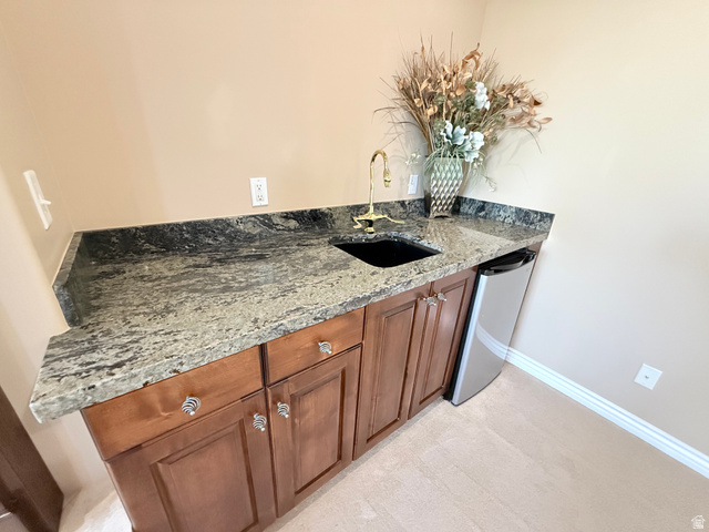 1562 Fairway Ridge Road Draper, UT 84020 - Photo 41 of 60 Wet bar featuring a dark granite countertop with a polished finish, undermount sink, and a brass faucet