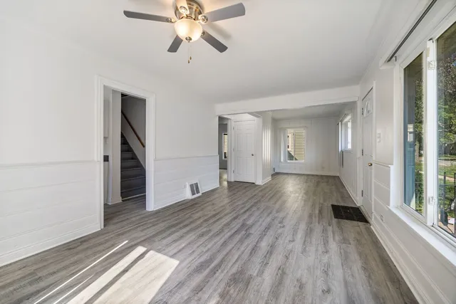 a view of a room with wooden floor staircase and a kitchen