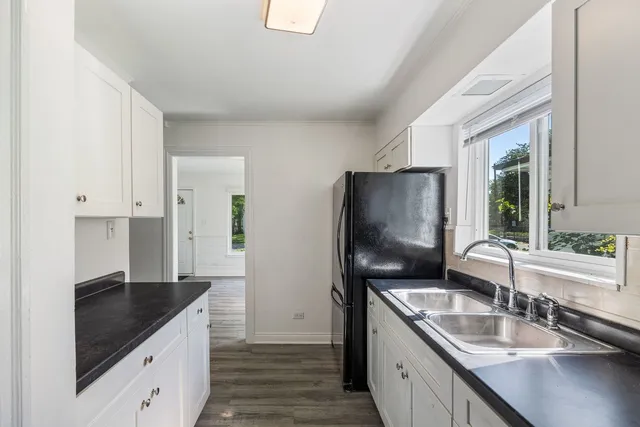 a kitchen with granite countertop a sink stove and refrigerator