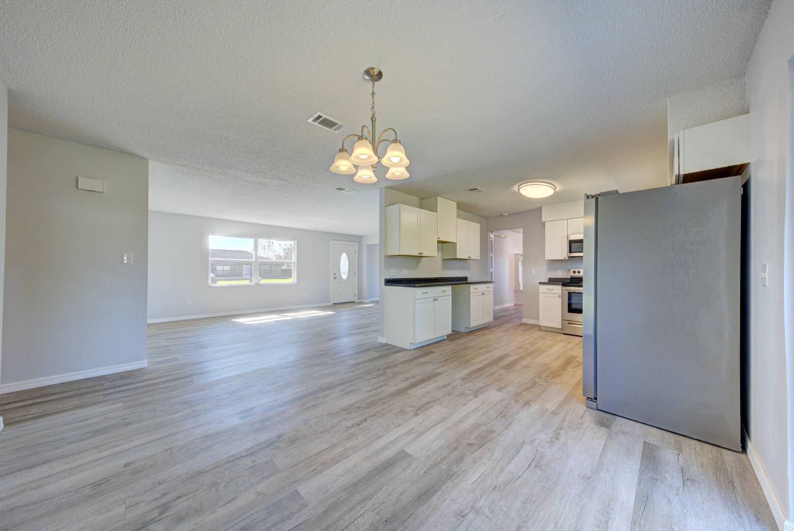 5356 Jamaica Road Cocoa, FL 32927 - Photo 11 of 41 a view of a kitchen with a refrigerator a ceiling fan and wooden floor