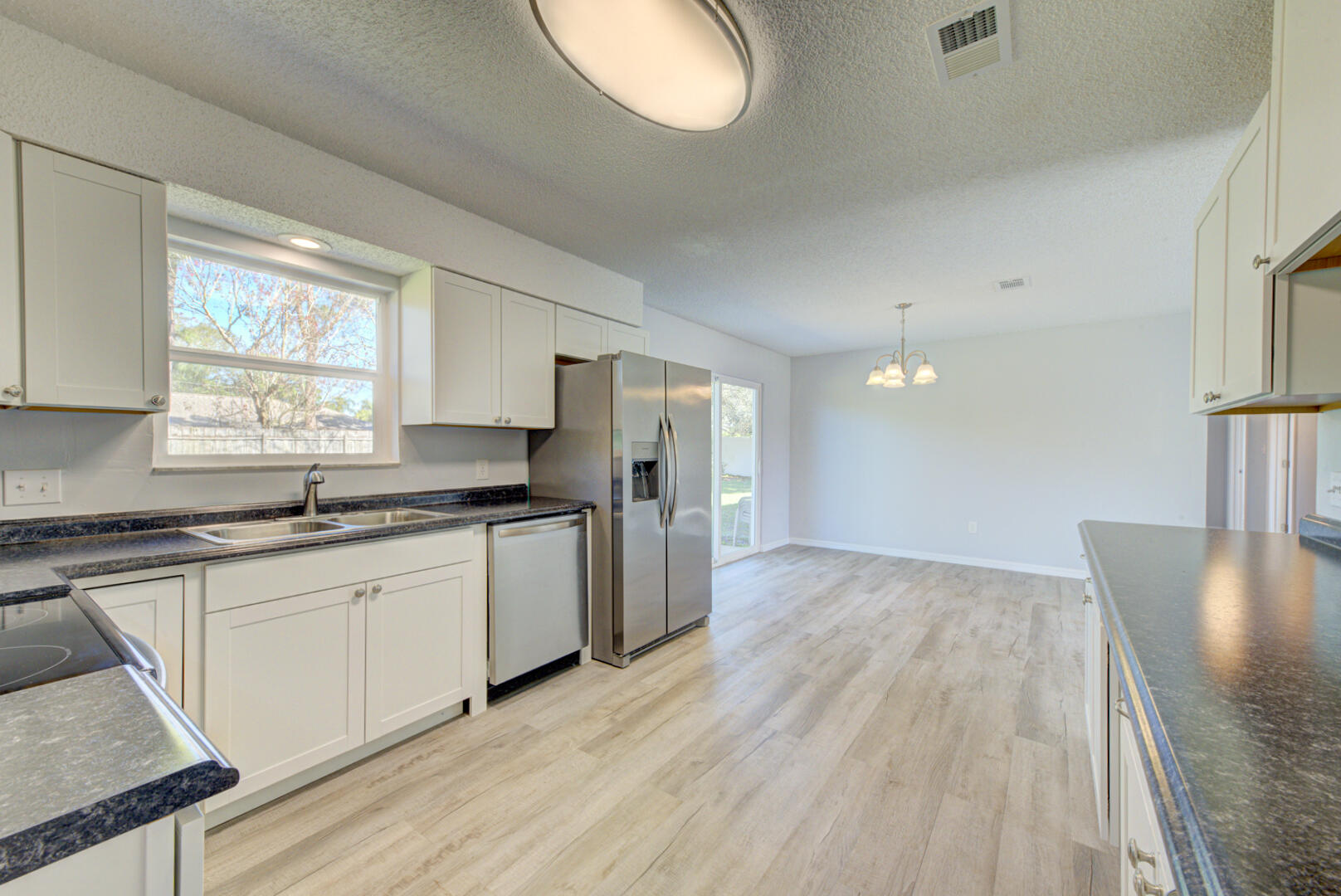 5356 Jamaica Road Cocoa, FL 32927 - Photo 14 of 41 a kitchen with granite countertop a stove a sink and a refrigerator