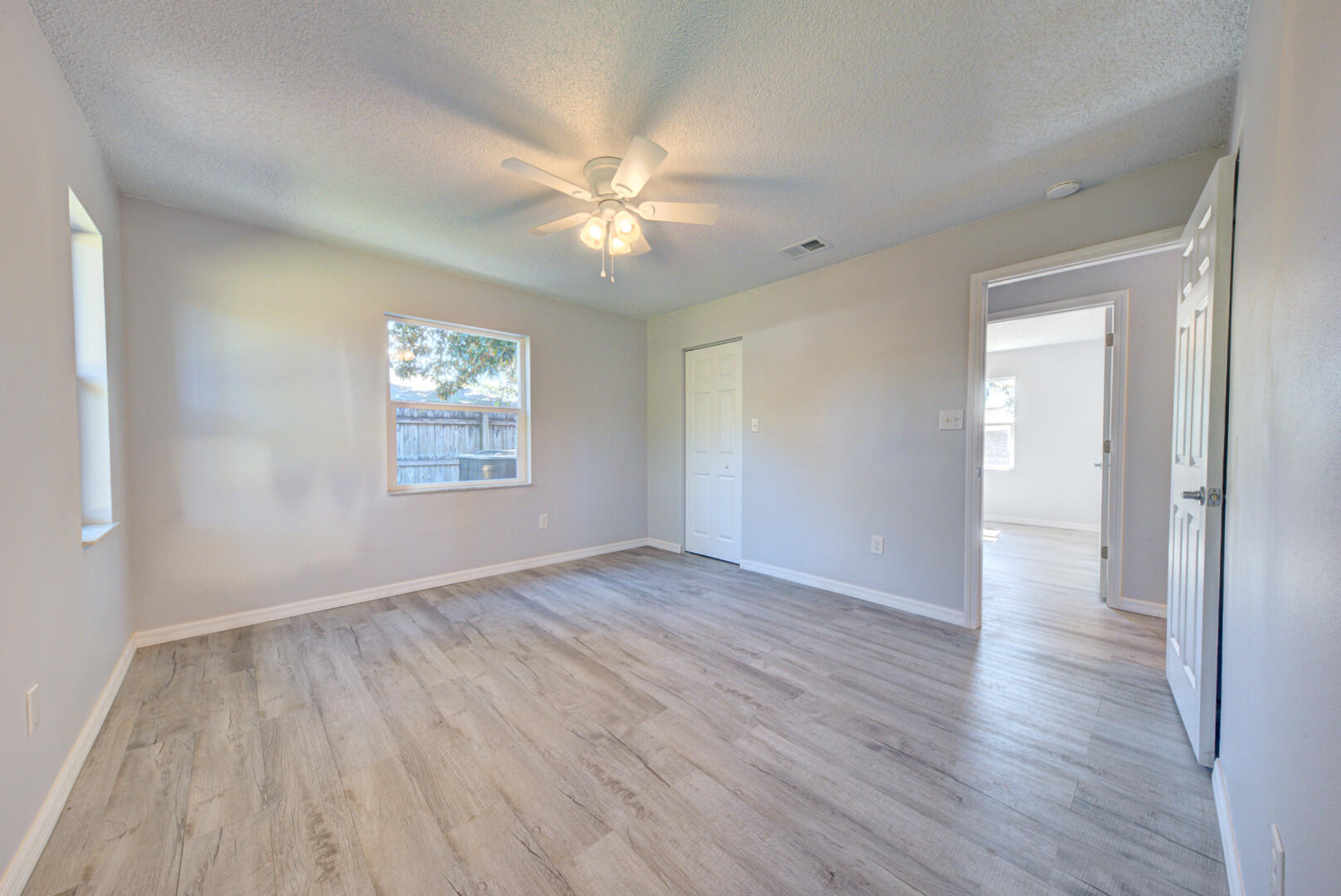 5356 Jamaica Road Cocoa, FL 32927 - Photo 26 of 41 a view of an empty room with wooden floor and a window
