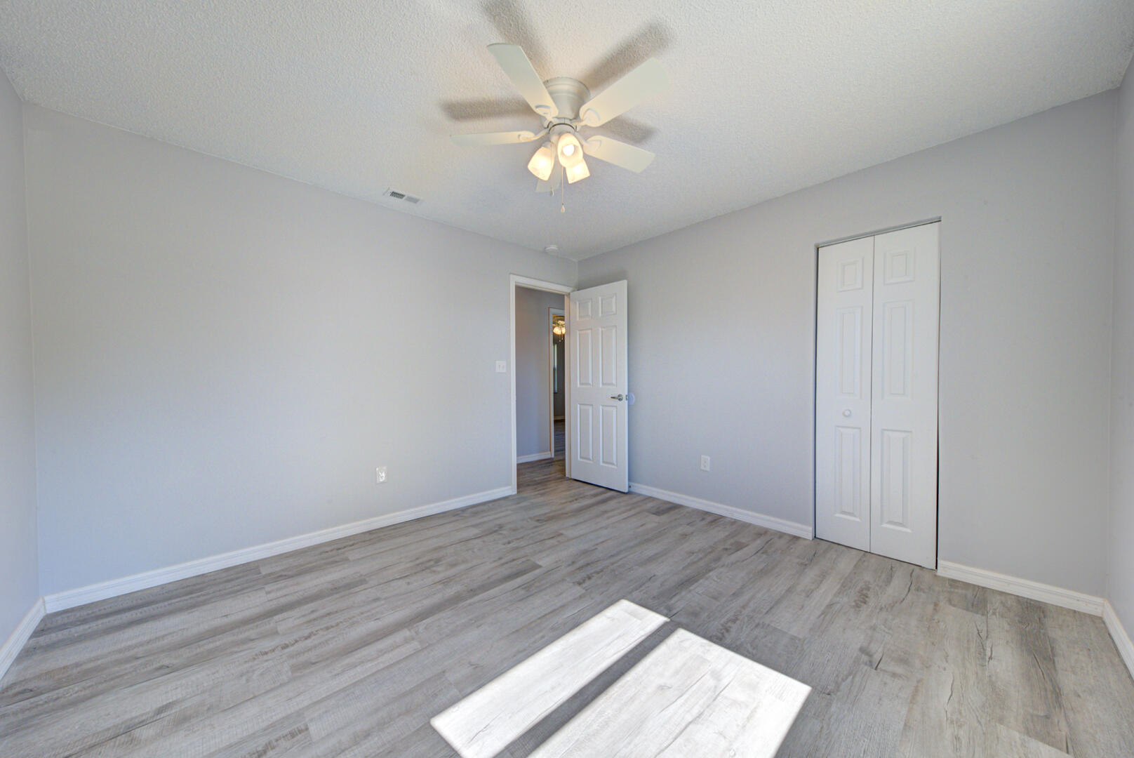 5356 Jamaica Road Cocoa, FL 32927 - Photo 27 of 41 an empty room with wooden floor and a ceiling fan