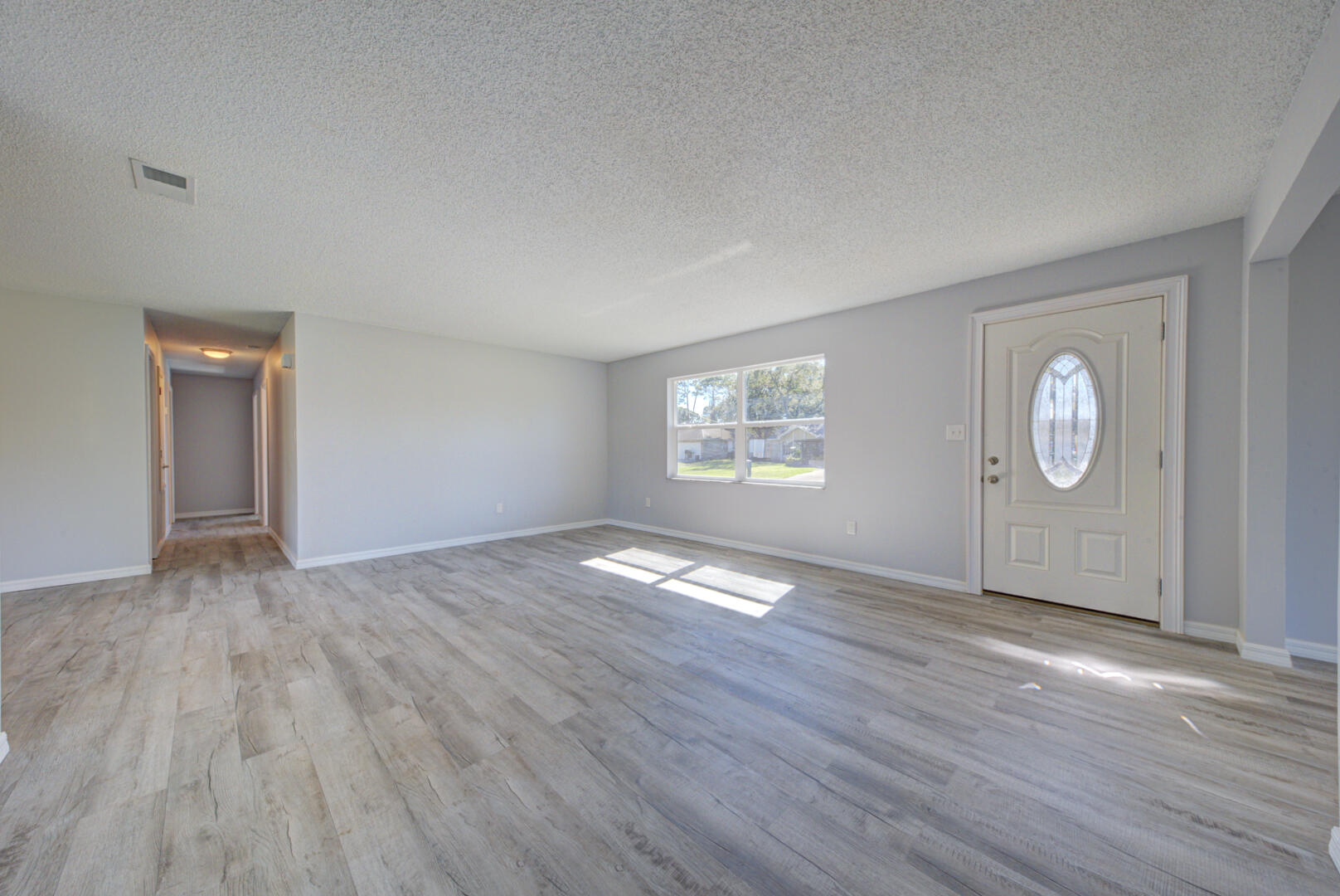 5356 Jamaica Road Cocoa, FL 32927 - Photo 4 of 41 an empty room with wooden floor and windows