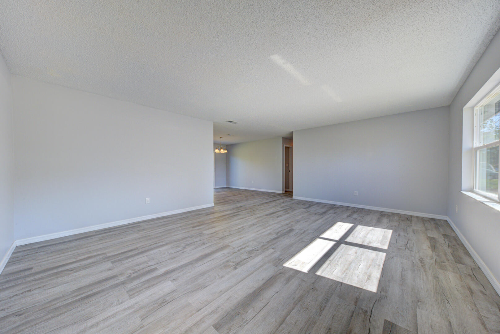 5356 Jamaica Road Cocoa, FL 32927 - Photo 5 of 41 an empty room with wooden floor and windows