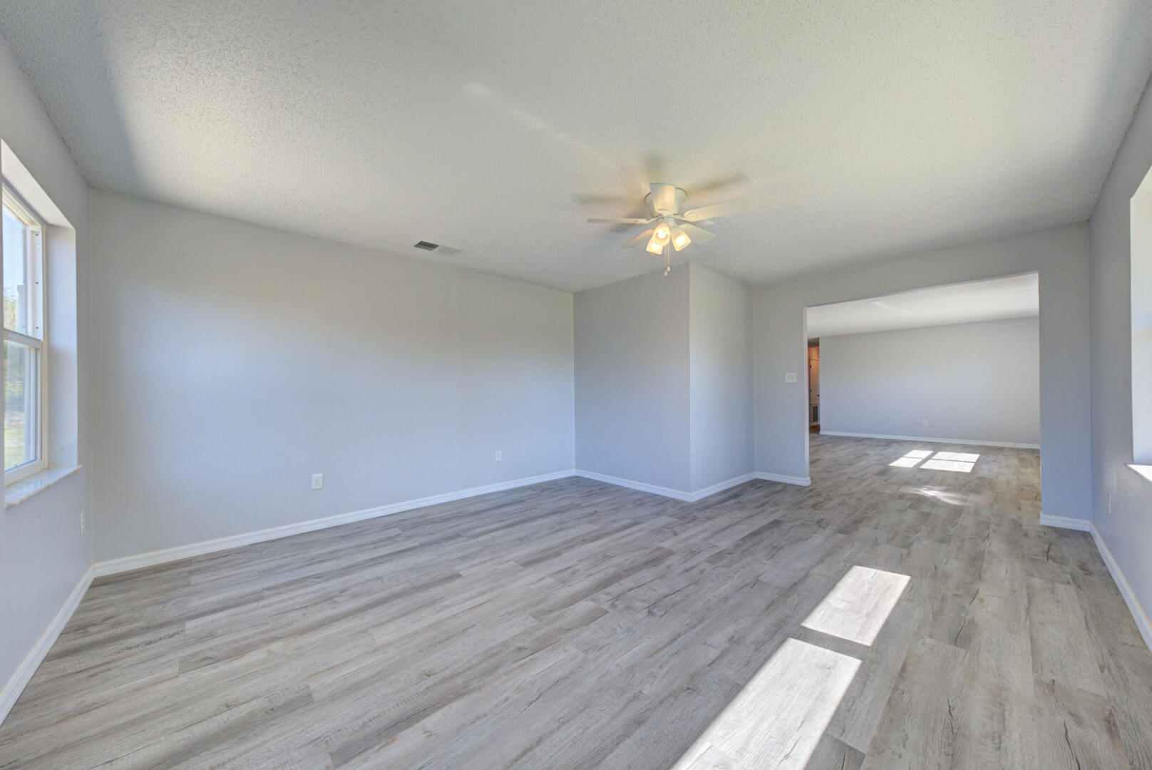 5356 Jamaica Road Cocoa, FL 32927 - Photo 9 of 41 a view of an empty room with wooden floor and a window