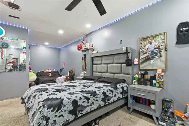 a bedroom with a bed a flat screen tv and a chandelier