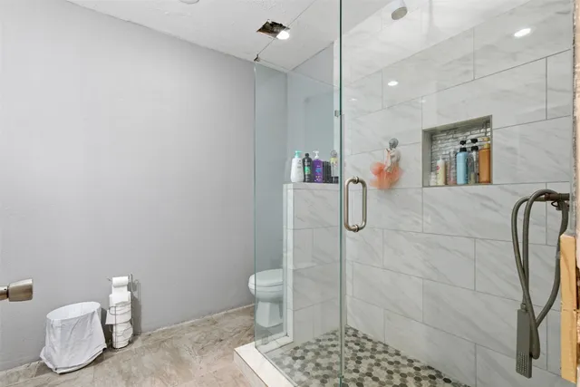 a bathroom with a toilet and a shower