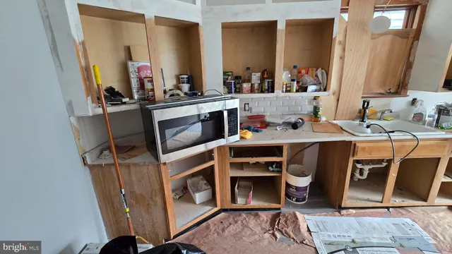 a room with a chair and white cabinets