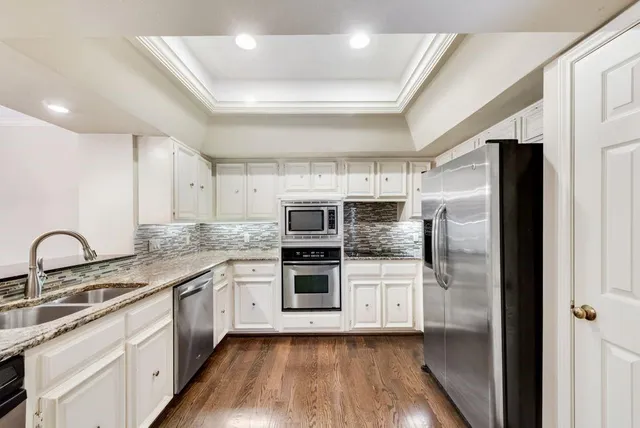 a kitchen with stainless steel appliances kitchen island granite countertop a stove a sink and a refrigerator