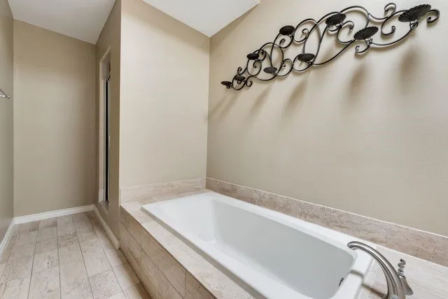 a bathroom with a granite countertop bathtub and a shower